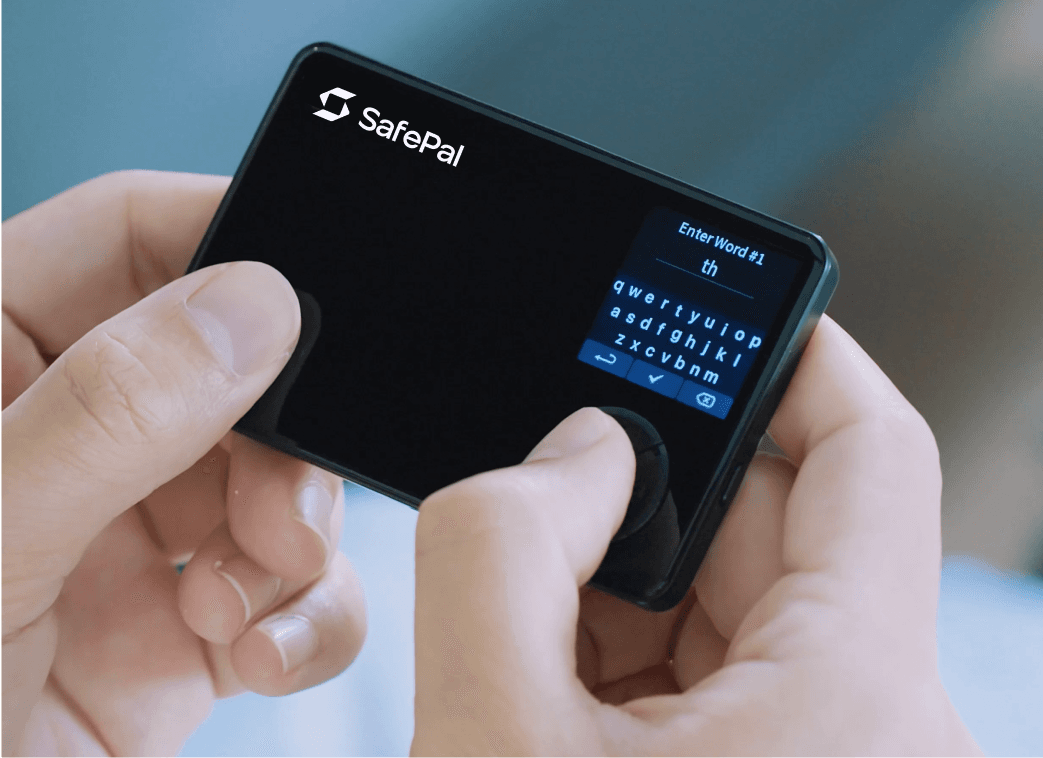 Hands entering a recovery seed word on the SafePal S1 device screen